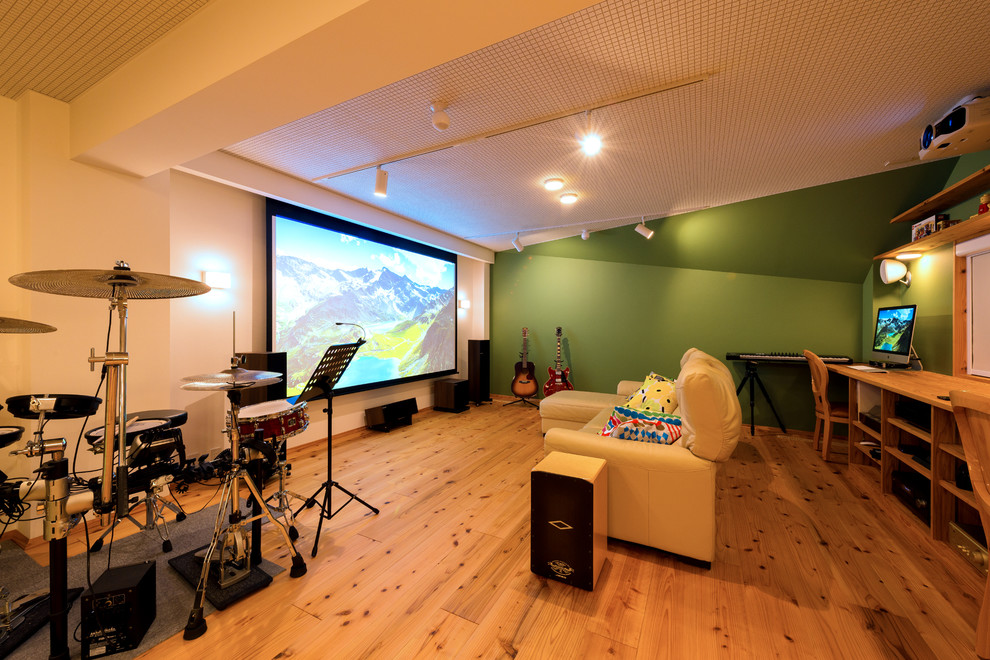Idee per un home theatre scandinavo chiuso con pareti verdi, pavimento in legno massello medio, schermo di proiezione e pavimento marrone