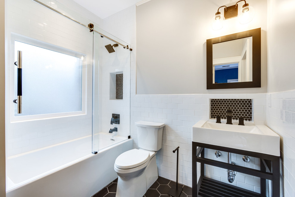 Photo of a small transitional kids bathroom in Birmingham with recessed-panel cabinets, turquoise cabinets, an alcove tub, a shower/bathtub combo, a two-piece toilet, white tile, subway tile, grey walls, porcelain floors, a console sink, engineered quartz benchtops, black floor, a sliding shower screen and white benchtops.