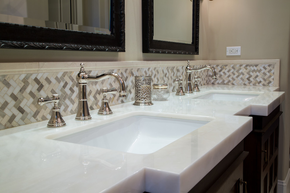 Photo of a large transitional master bathroom in Orange County with furniture-like cabinets, dark wood cabinets, a freestanding tub, beige tile, porcelain tile, beige walls, ceramic floors, an undermount sink, marble benchtops and an alcove shower.
