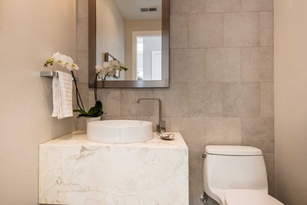 Modern cloakroom in San Francisco with a one-piece toilet, beige tiles, limestone tiles, beige walls, a vessel sink and a floating vanity unit.