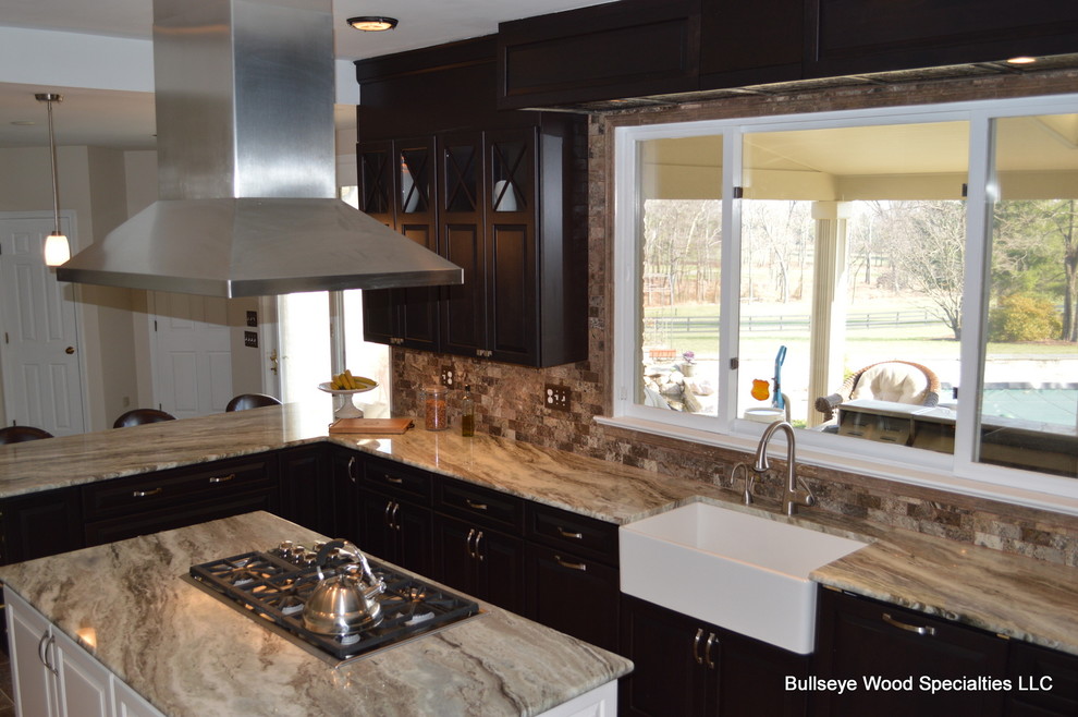 Mid-sized country l-shaped eat-in kitchen in DC Metro with a farmhouse sink, raised-panel cabinets, dark wood cabinets, beige splashback, stainless steel appliances and with island.