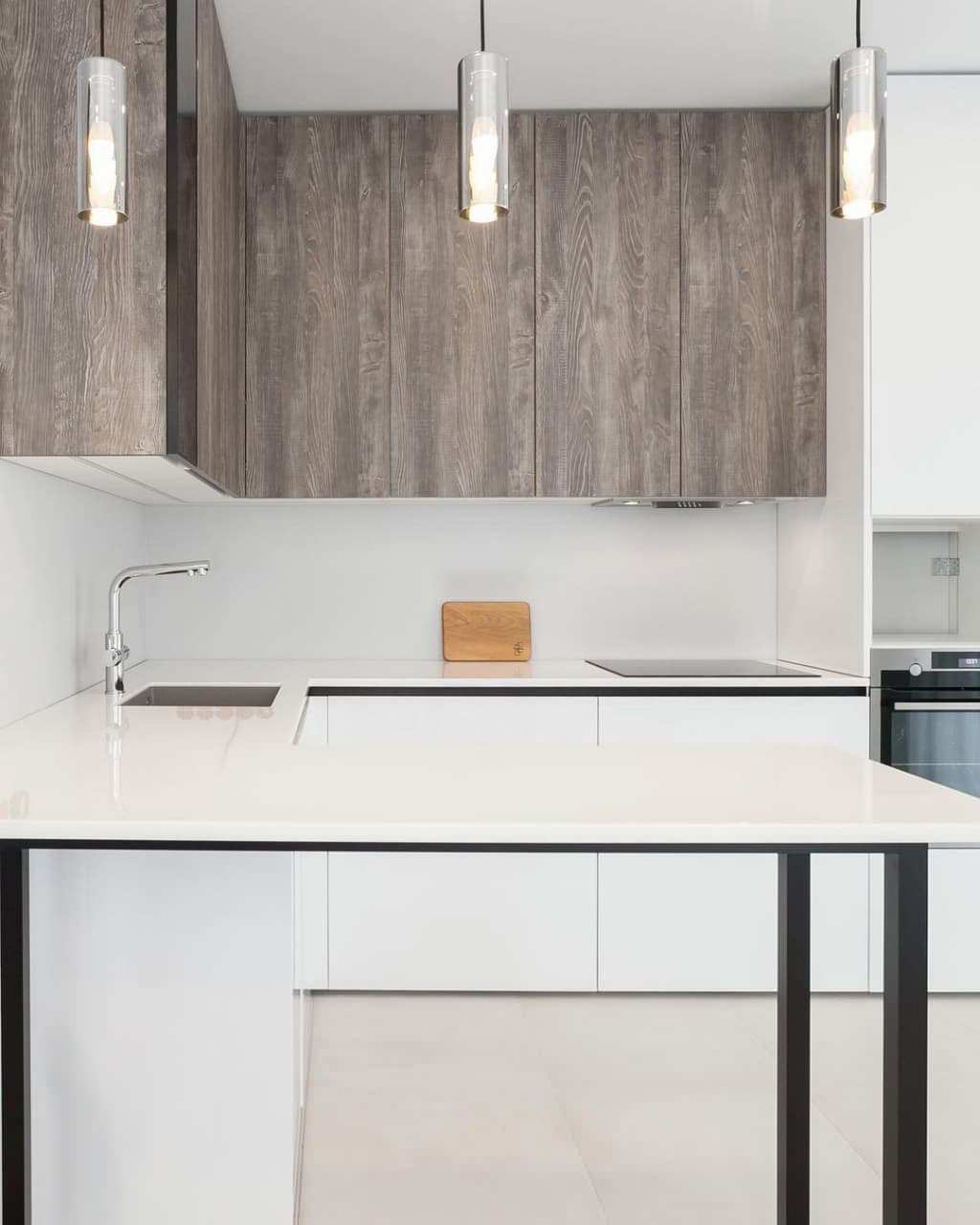 Современная серо-белая кухня в высокими шкафами и барной стойкой