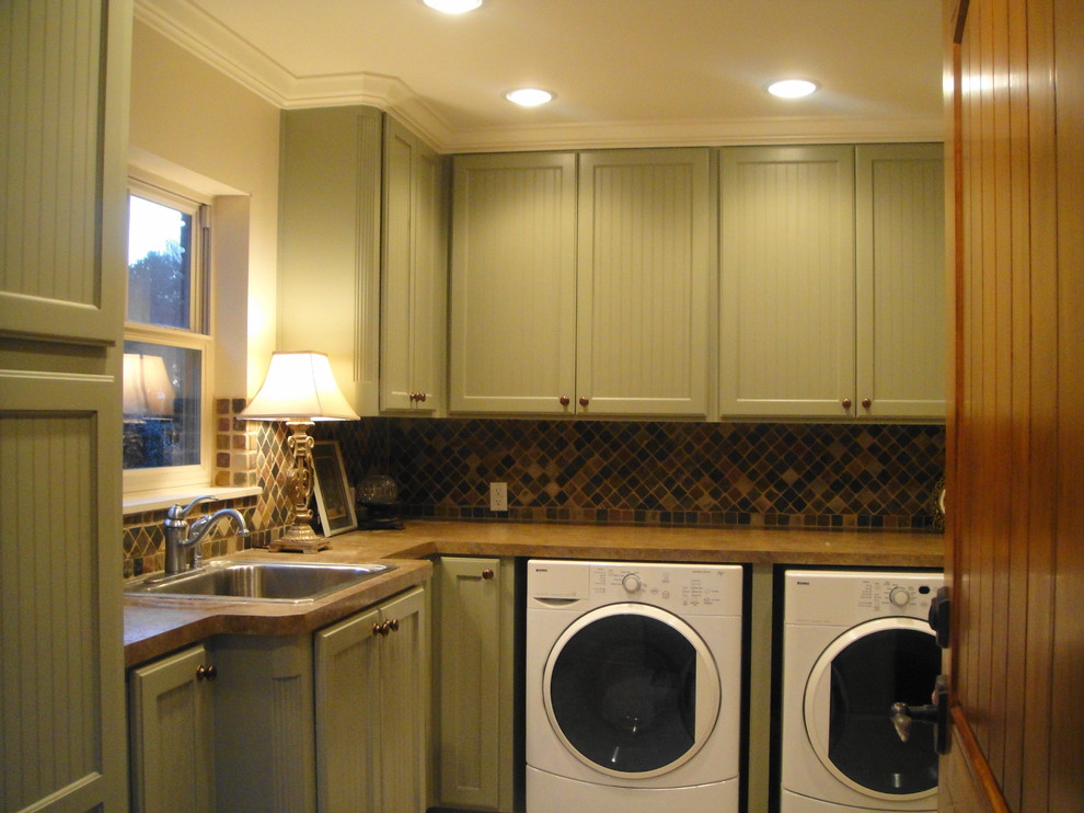 Photo of a traditional laundry room in Other with green cabinets.