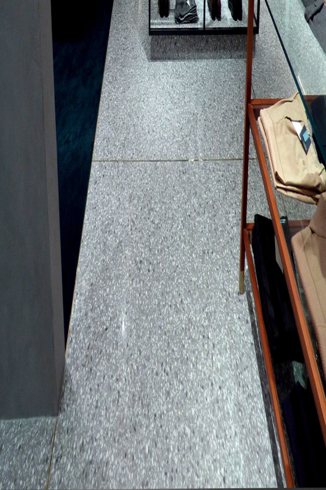 Exemple d'un grand couloir moderne avec un mur gris, un sol en terrazzo et un sol gris.
