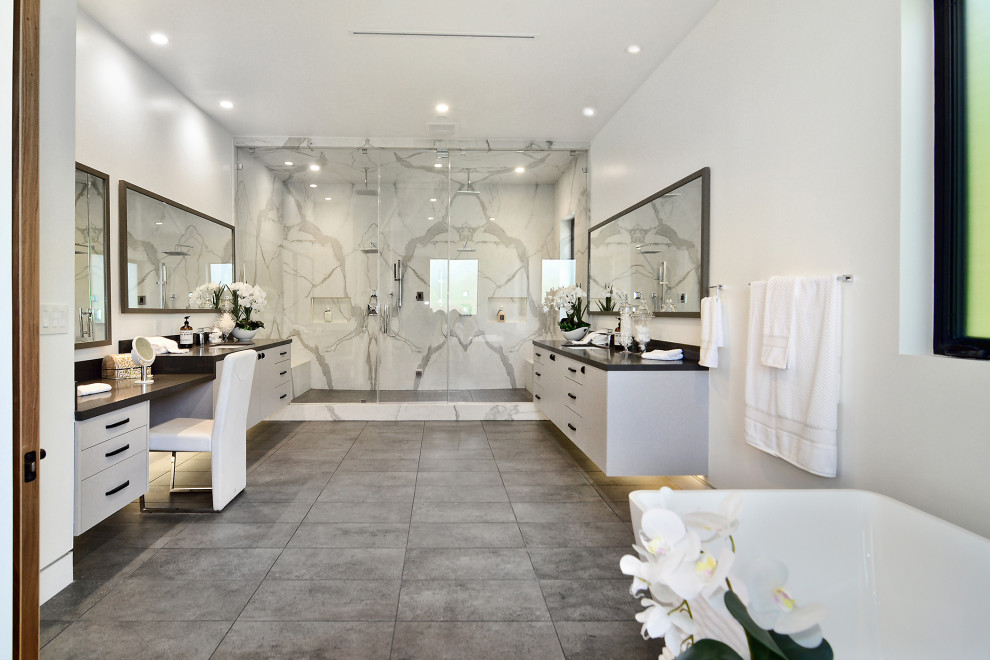 Inspiration for a large contemporary master bathroom in Los Angeles with flat-panel cabinets, white cabinets, a freestanding tub, a double shower, marble, engineered quartz benchtops, a hinged shower door, black benchtops, a double vanity and a floating vanity.