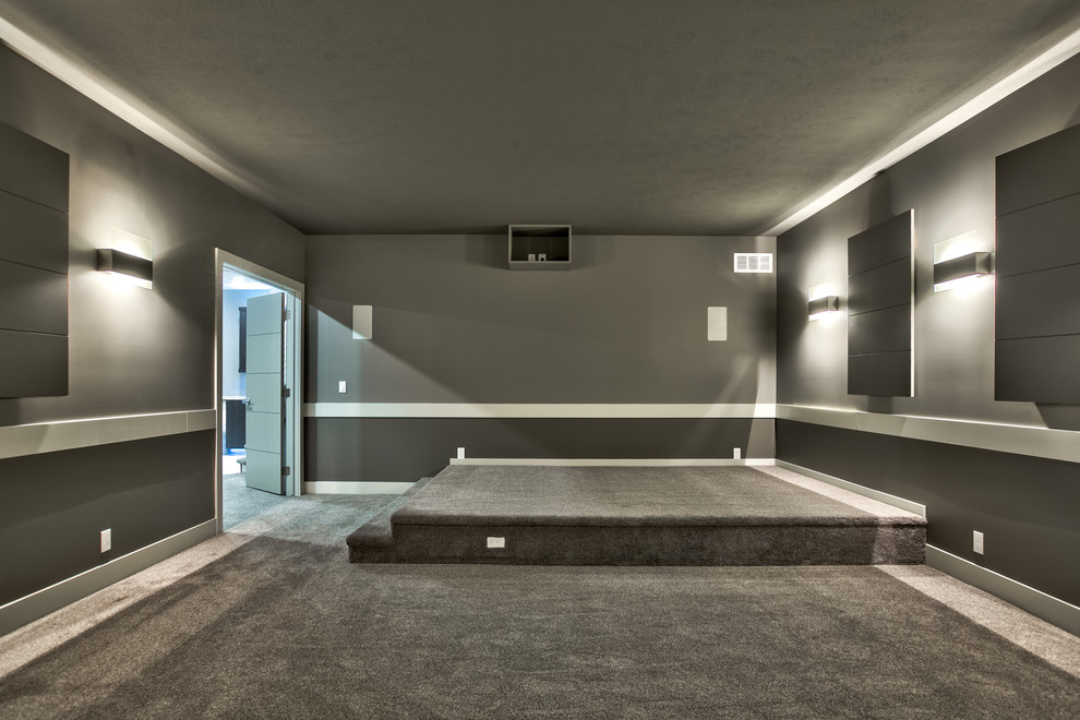 Photo of a large modern enclosed home theatre in Omaha with grey walls, carpet and a projector screen.