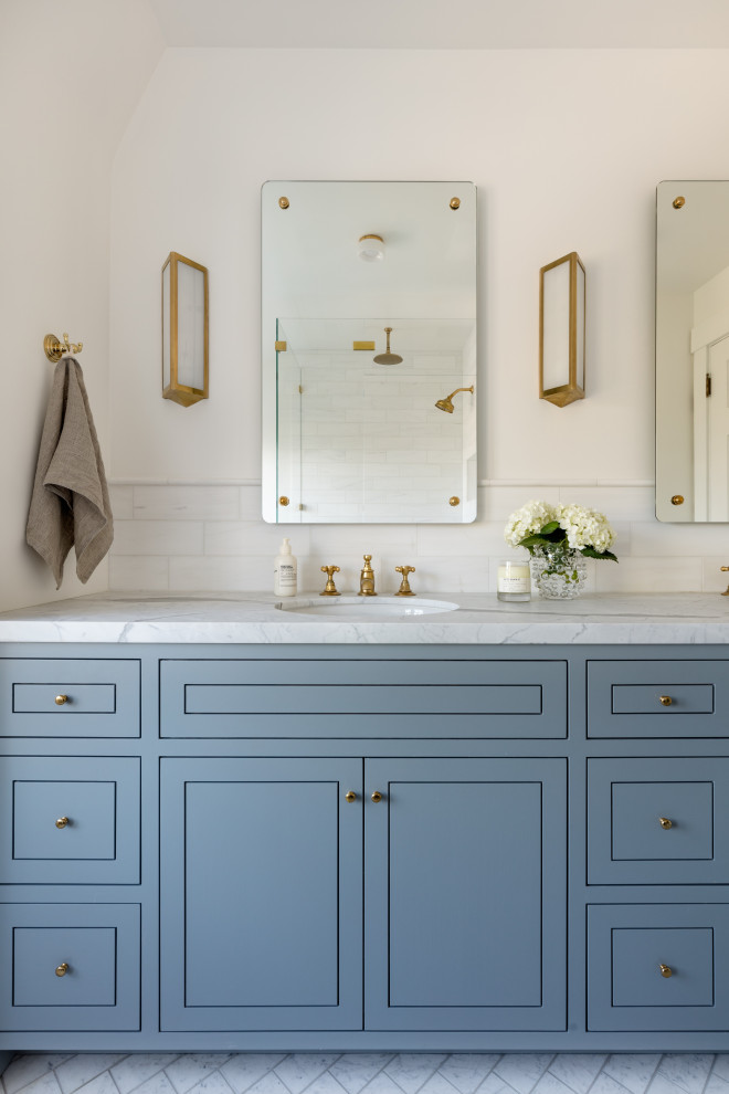 Large transitional master white tile and matchstick tile marble floor, white floor and double-sink corner shower photo in Seattle with furniture-like cabinets, blue cabinets, a one-piece toilet, white walls, an undermount sink, marble countertops, a hinged shower door, white countertops and a built-in vanity