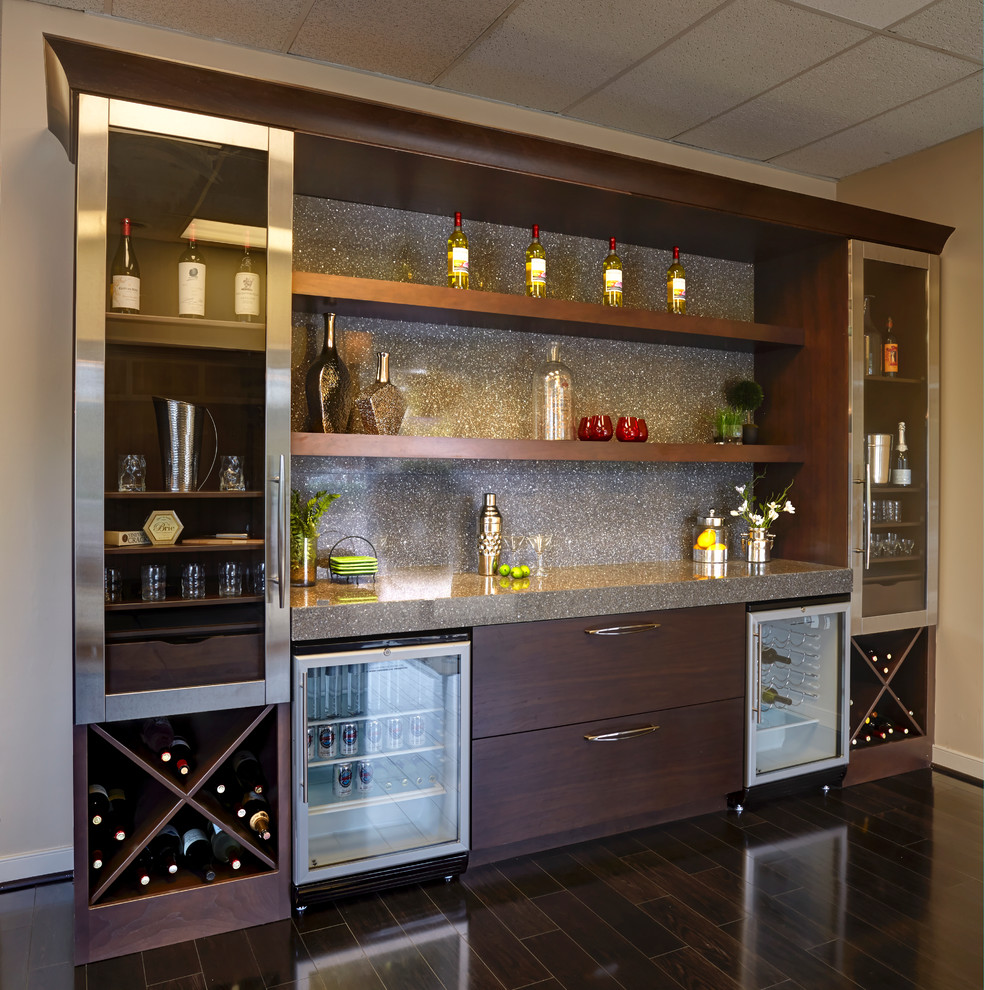 This is an example of a mid-sized contemporary single-wall wet bar in Baltimore with dark hardwood floors, flat-panel cabinets, dark wood cabinets, laminate benchtops, grey splashback, stone slab splashback and brown floor.