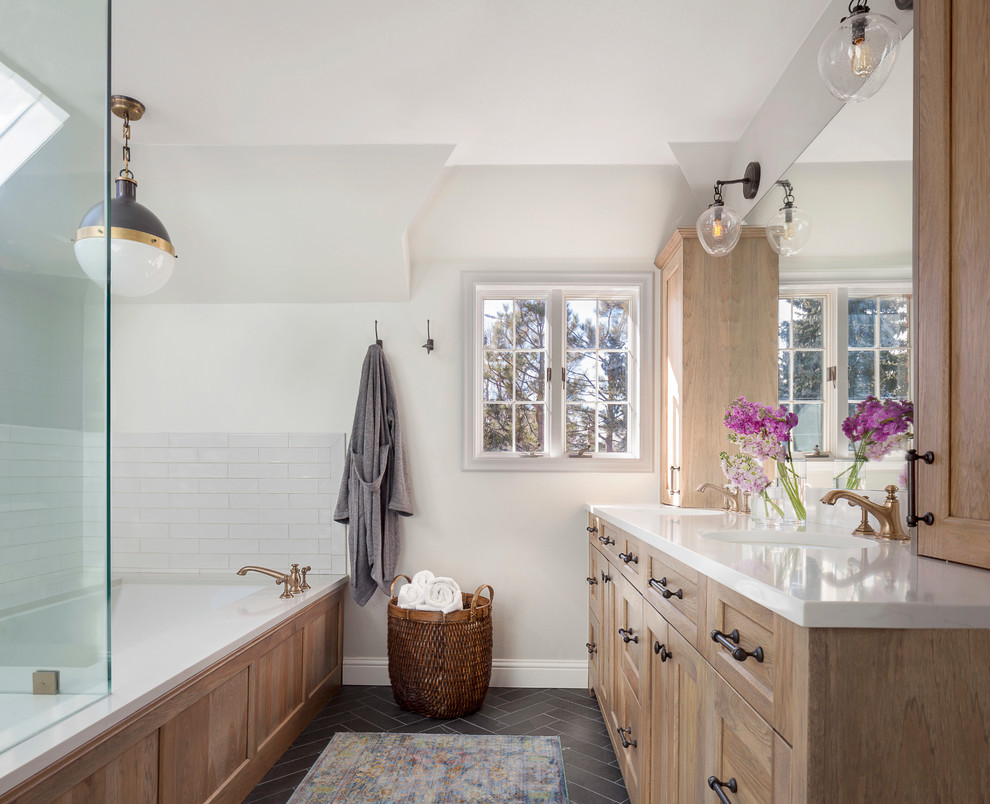 Large country master bathroom in Denver with light wood cabinets, white tile, subway tile, white walls, an undermount sink, grey floor, a hinged shower door, white benchtops, shaker cabinets and a corner tub.