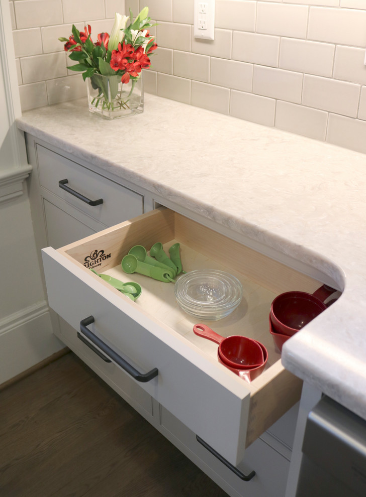 Enclosed kitchen - large transitional galley medium tone wood floor and brown floor enclosed kitchen idea with a farmhouse sink, shaker cabinets, gray cabinets, quartzite countertops, beige backsplash, subway tile backsplash, stainless steel appliances and a peninsula