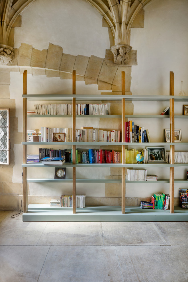 Immagine di uno studio minimal con libreria, pareti beige, pavimento grigio e soffitto a volta