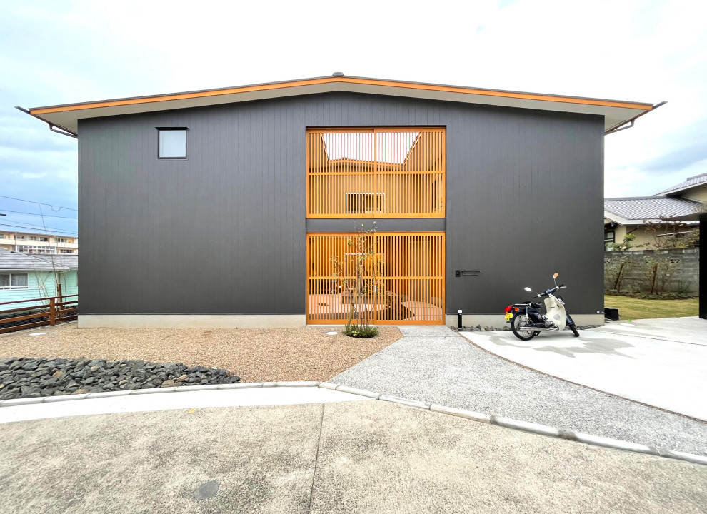 Photo of a mid-sized two-storey grey house exterior in Fukuoka with metal siding, a gable roof, a metal roof and a grey roof.