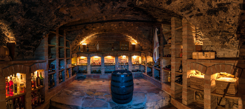 Inspiration for a country wine cellar in Other with brick floors, storage racks and orange floor.