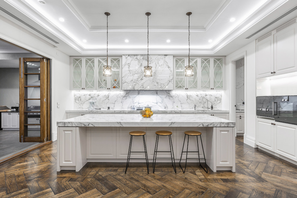 Inspiration for a large transitional eat-in kitchen in Melbourne with an undermount sink, glass-front cabinets, white cabinets, marble benchtops, marble splashback, black appliances, dark hardwood floors and with island.