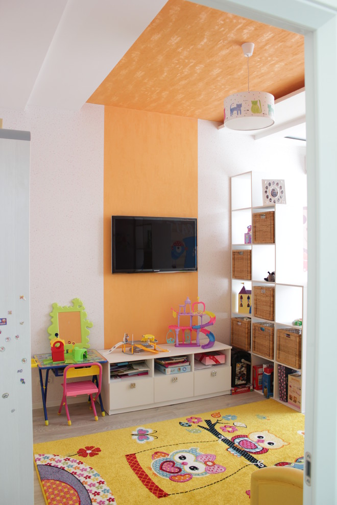 Idée de décoration pour une chambre d'enfant de 1 à 3 ans design de taille moyenne avec un mur orange, sol en stratifié et un sol beige.