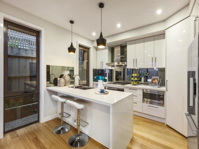 Inspiration for a mid-sized contemporary single-wall kitchen pantry in Melbourne with a double-bowl sink, recessed-panel cabinets, white cabinets, granite benchtops, metallic splashback, glass tile splashback, stainless steel appliances, light hardwood floors and with island.
