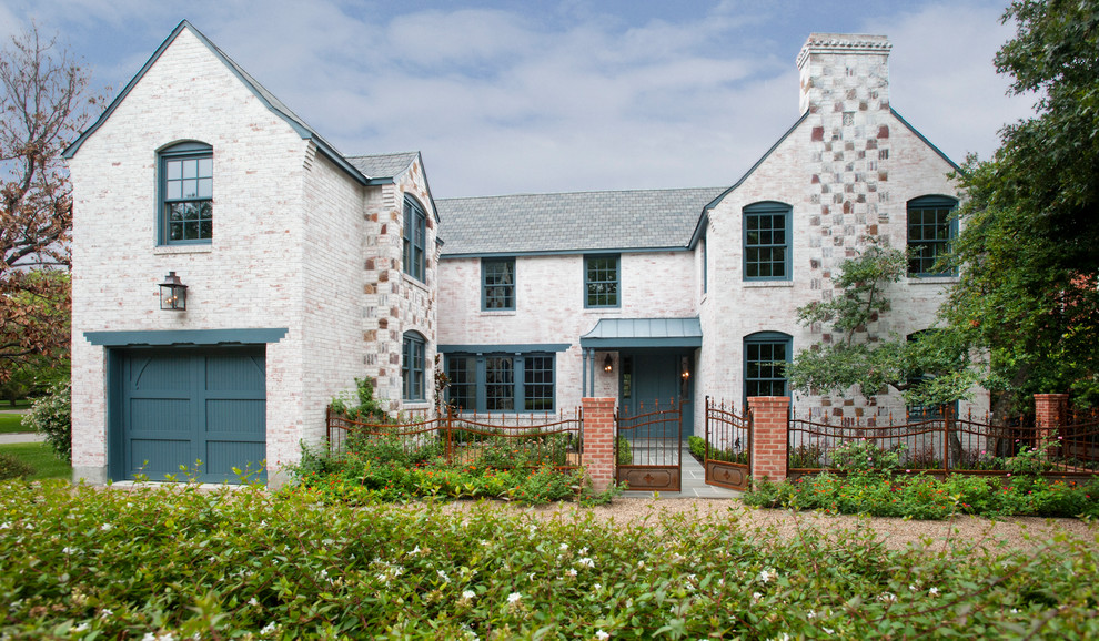 This is an example of a large traditional two-storey brick white exterior in Dallas with a gable roof.