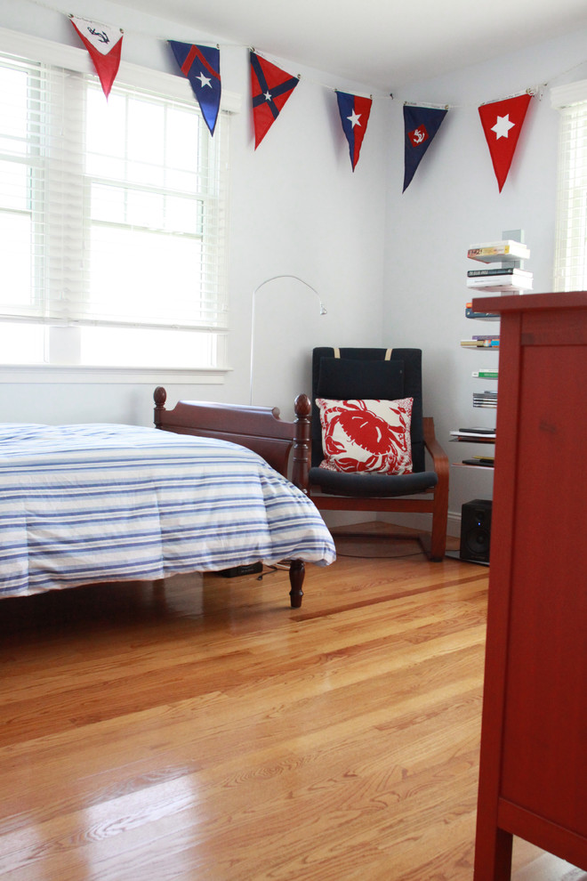 This is an example of a mid-sized beach style kids' bedroom for kids 4-10 years old and boys in Boston with blue walls and light hardwood floors.
