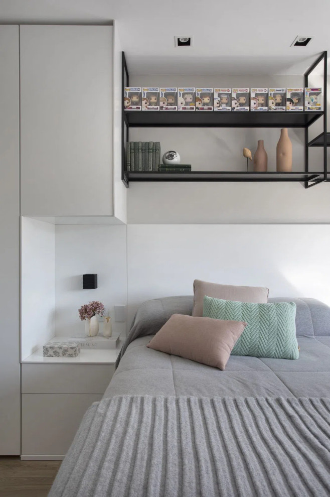 Imagen de dormitorio tipo loft moderno pequeño con paredes blancas, suelo laminado y suelo beige