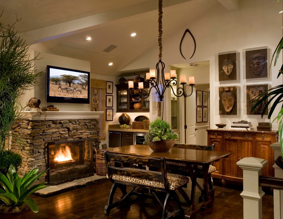 Inspiration for a mediterranean dining room in Orange County with a stone fireplace surround.
