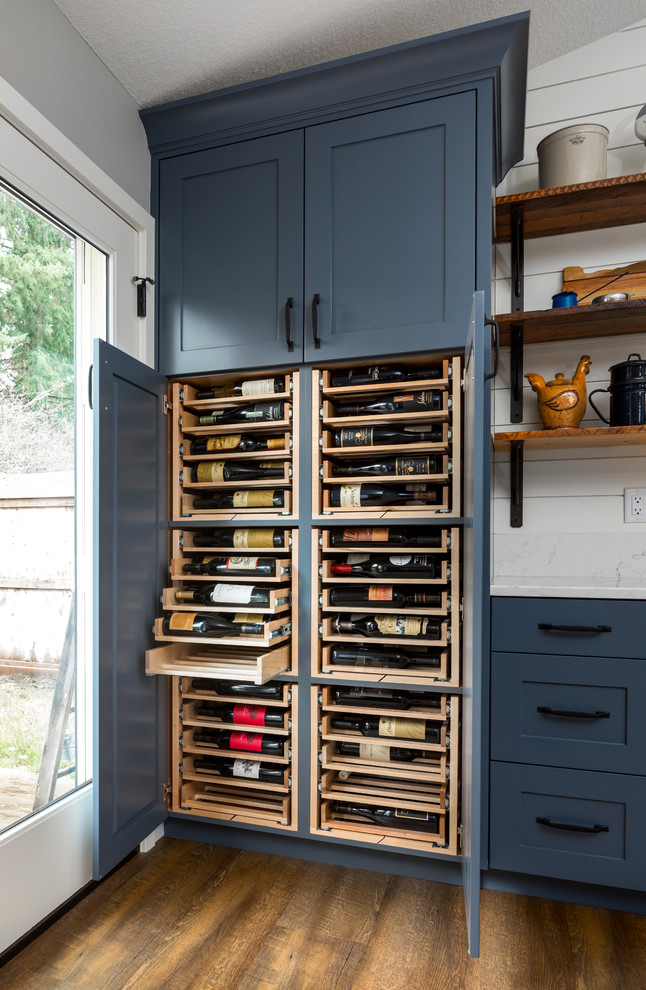 Inspiration for a large country galley open plan kitchen in Portland with a farmhouse sink, shaker cabinets, blue cabinets, quartz benchtops, white splashback, timber splashback, stainless steel appliances, vinyl floors, with island and brown floor.