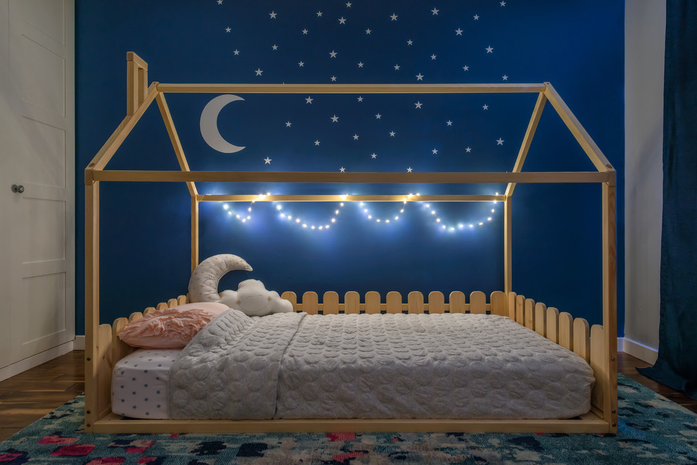 Edgewood - Fairy Tail Bedrooms - Fun, cheerful little girl's room featuring custom house twin bed frame, bright rug, fun twinkly lights, golden lamp, comfy gray reading chair and custom blue drapes. Photo by Exceptional Frames.