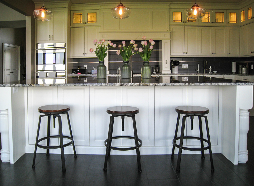 Transitional l-shaped gray floor eat-in kitchen photo in Toronto with an undermount sink, white cabinets, granite countertops, gray backsplash, stainless steel appliances and an island