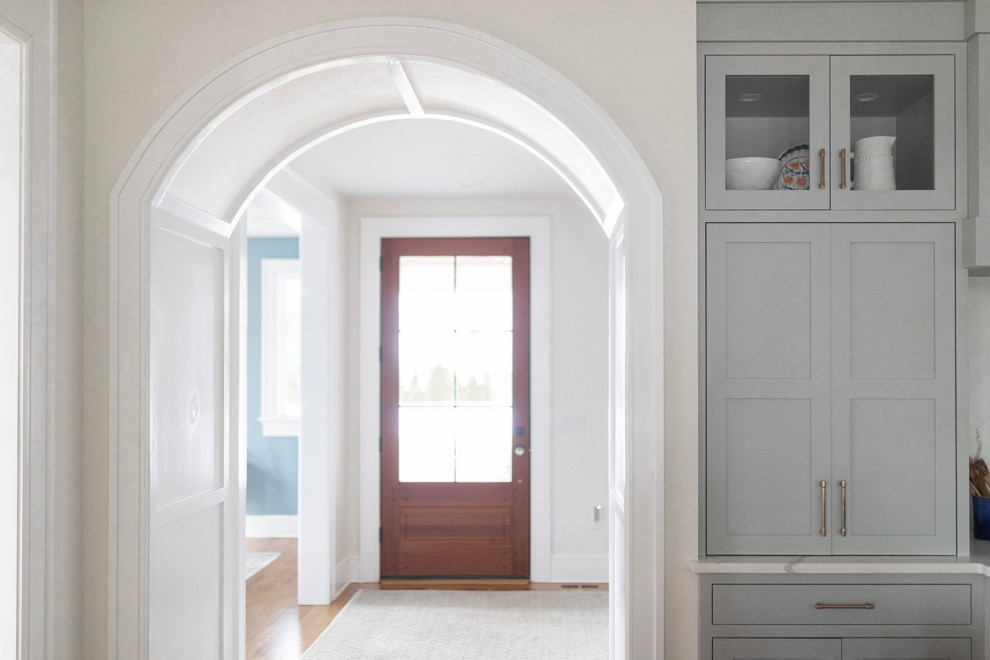 Inspiration pour un hall d'entrée traditionnel de taille moyenne avec un mur blanc, un sol en bois brun, une porte simple, une porte en bois foncé, un sol marron et du lambris.