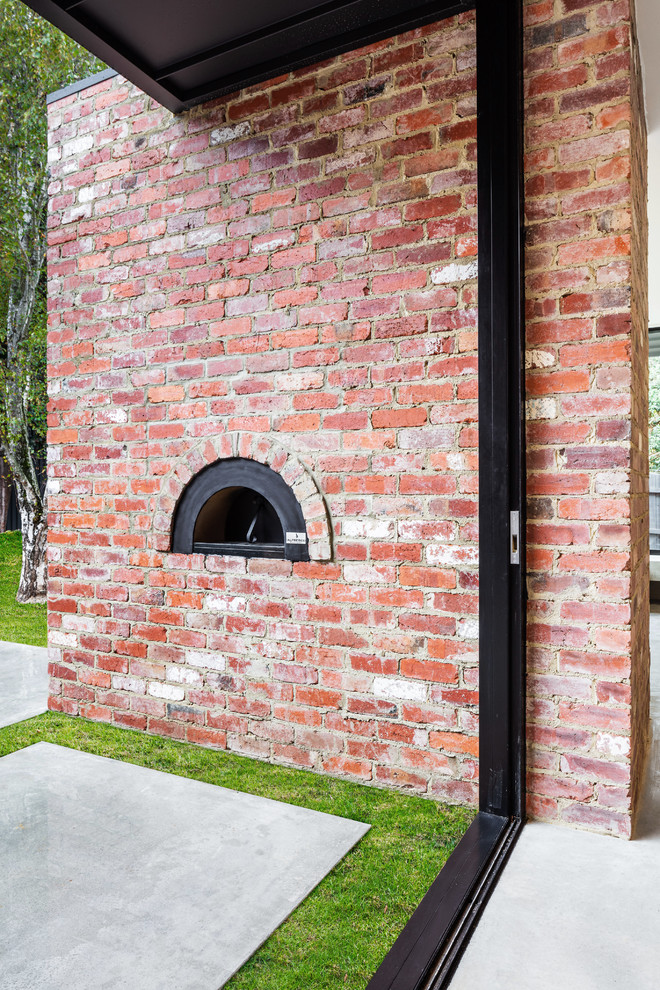 Photo of a large contemporary backyard patio in Melbourne with an outdoor kitchen, concrete slab and a roof extension.