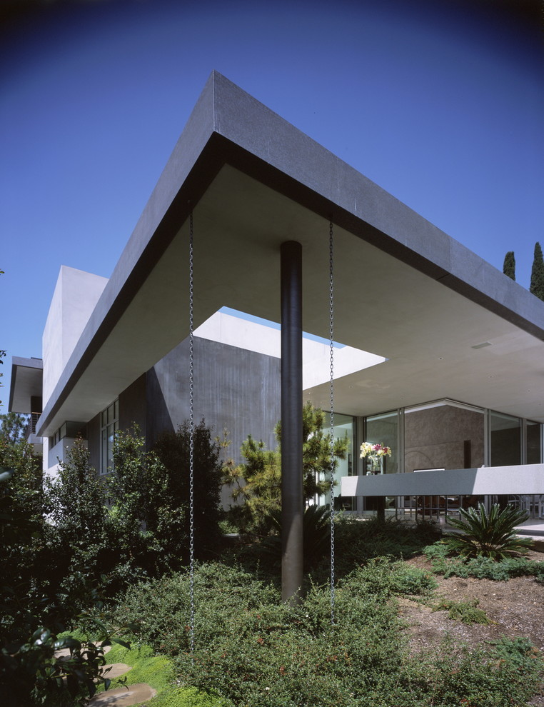 Inspiration for a modern stucco house exterior in Los Angeles with a flat roof.