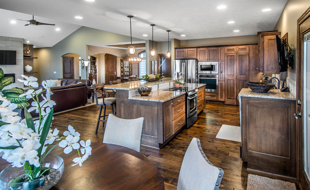 Inspiration for a mid-sized medium tone wood floor kitchen remodel with an undermount sink, recessed-panel cabinets, medium tone wood cabinets, granite countertops, beige backsplash, ceramic backsplash, stainless steel appliances and an island