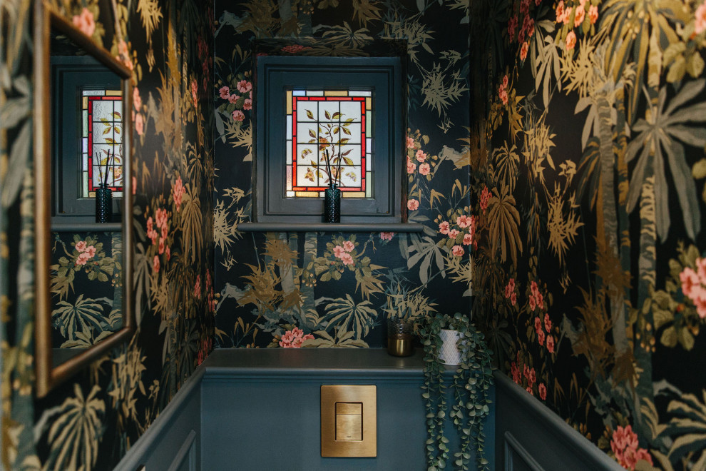 Inspiration for a small classic cloakroom in London with a wall mounted toilet, a built-in sink, white worktops, black walls, a dado rail and wallpapered walls.