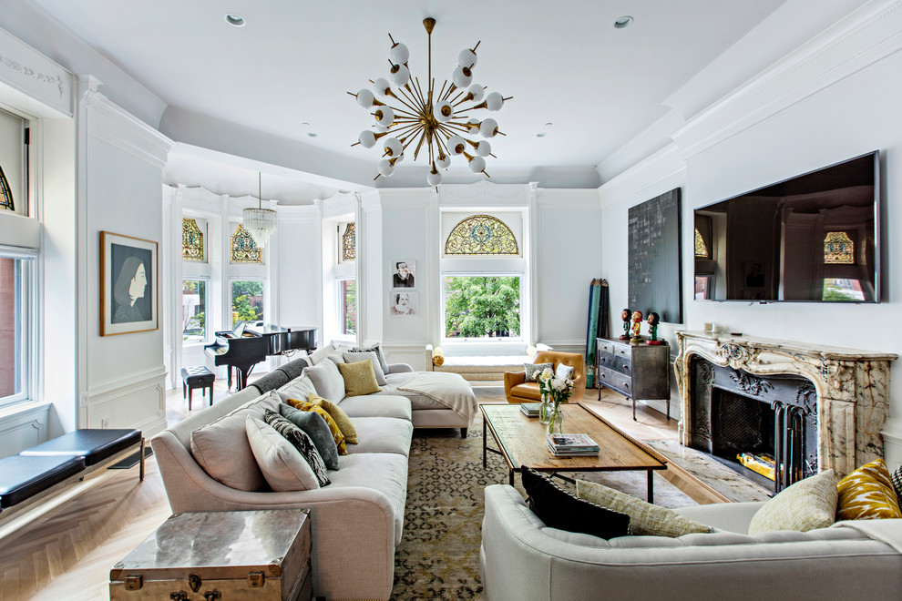 This is an example of a large eclectic open concept living room in New York with white walls, a standard fireplace, a metal fireplace surround, a wall-mounted tv, a music area, medium hardwood floors and brown floor.