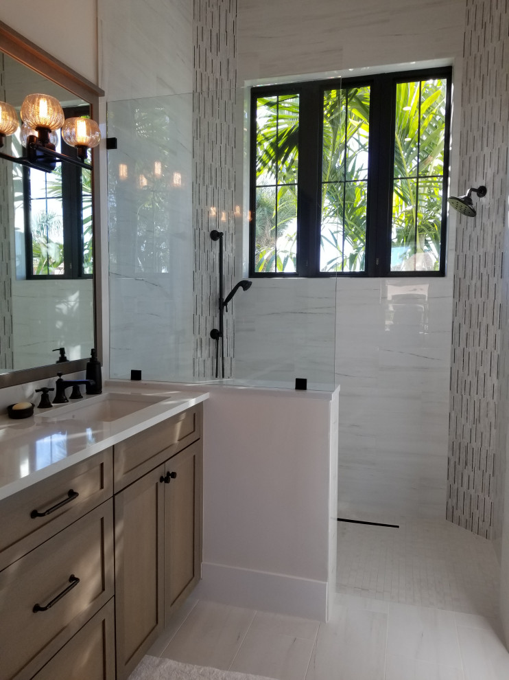 Large transitional 3/4 bathroom in Miami with shaker cabinets, distressed cabinets, an open shower, a two-piece toilet, beige tile, porcelain tile, beige walls, porcelain floors, an undermount sink, engineered quartz benchtops, beige floor, an open shower and white benchtops.