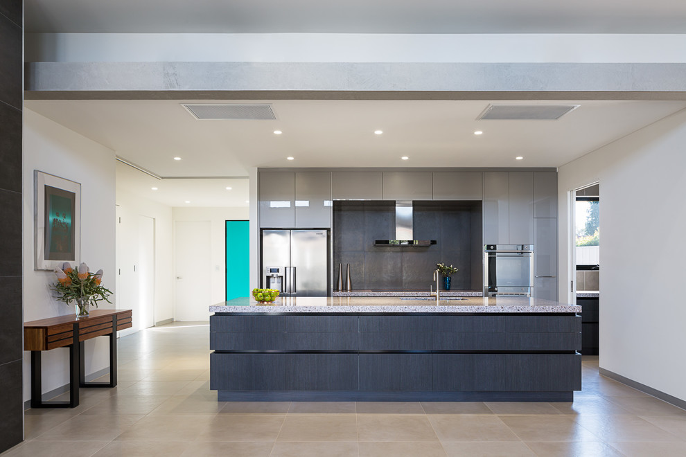 Photo of a large contemporary galley open plan kitchen in Melbourne with a double-bowl sink, flat-panel cabinets, marble benchtops, grey splashback, porcelain splashback, stainless steel appliances and with island.