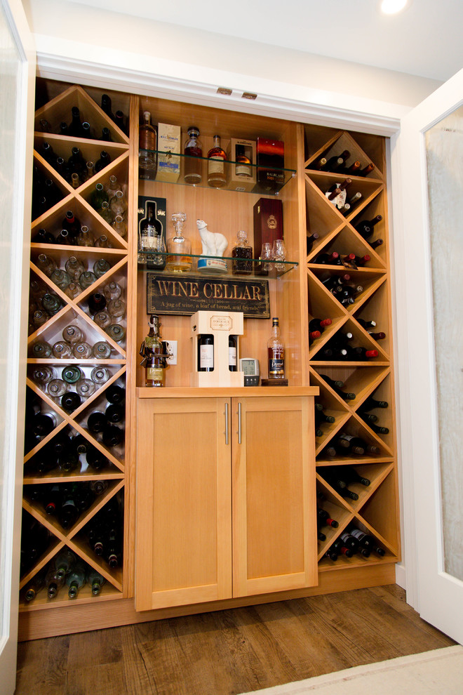 Inspiration for a small traditional wine cellar in Calgary with vinyl floors, display racks and brown floor.