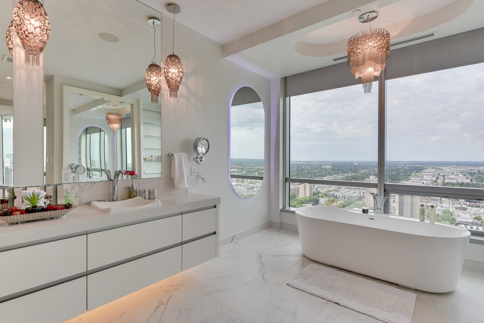 Large contemporary master bathroom in Calgary with flat-panel cabinets, white cabinets, a freestanding tub, a corner shower, a one-piece toilet, white tile, porcelain tile, white walls, marble floors, a drop-in sink and marble benchtops.
