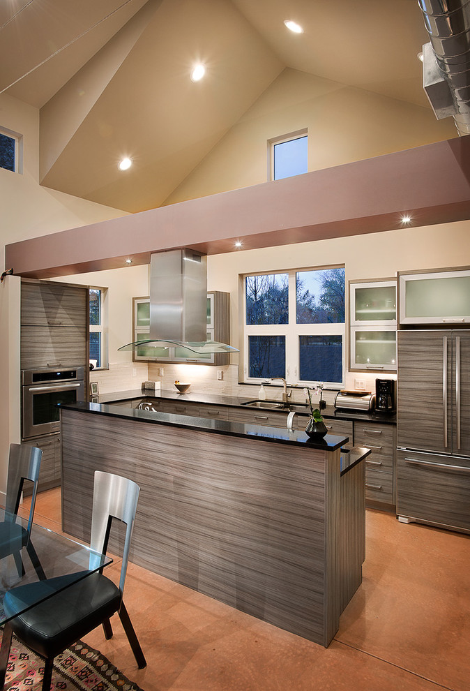 Mid-sized contemporary u-shaped open plan kitchen in Albuquerque with an undermount sink, flat-panel cabinets, medium wood cabinets, quartz benchtops, white splashback, ceramic splashback, panelled appliances, concrete floors, with island and brown floor.
