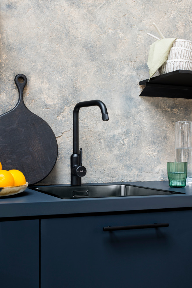 Immagine di una piccola cucina moderna con lavello a vasca singola, ante lisce, ante blu, top in legno, paraspruzzi grigio, paraspruzzi in lastra di pietra, elettrodomestici neri e top blu