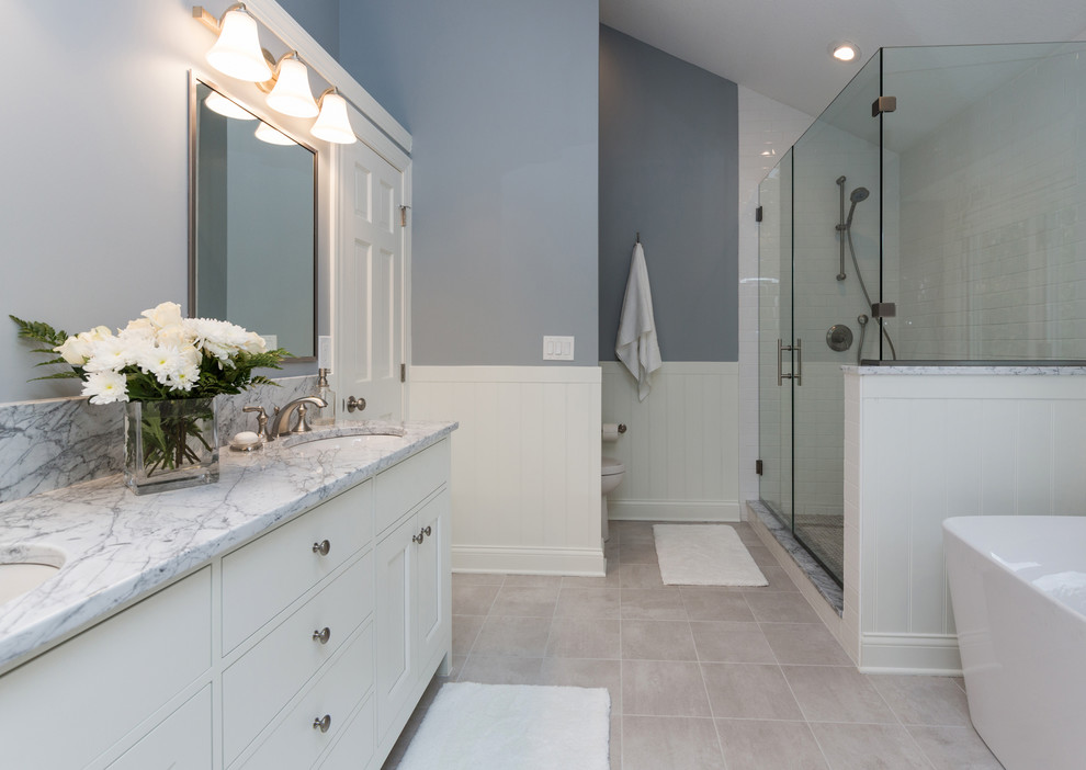 Freestanding bathtub - mid-sized transitional master ceramic tile freestanding bathtub idea with an undermount sink, furniture-like cabinets, white cabinets, marble countertops, a two-piece toilet and gray walls