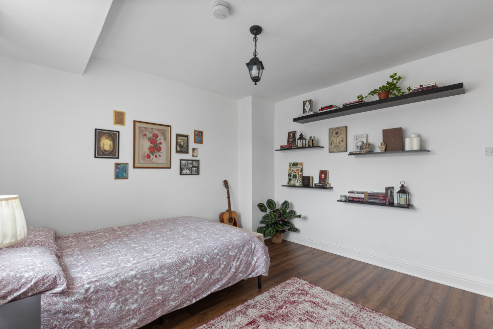 Foto de dormitorio principal y blanco contemporáneo de tamaño medio con paredes blancas, suelo laminado y suelo marrón