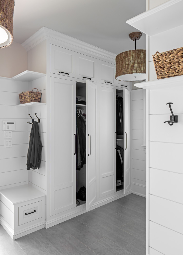 Design ideas for a beach style mudroom in Other with white walls and grey floor.