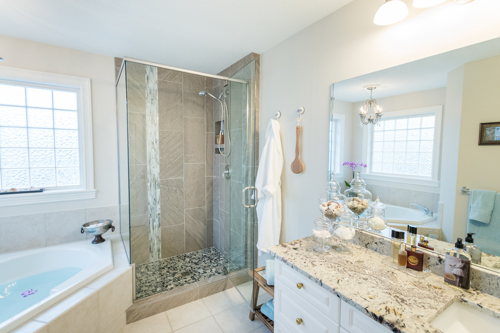 Inspiration for a small traditional master bathroom in Edmonton with shaker cabinets, white cabinets, a corner tub, a corner shower, a one-piece toilet, multi-coloured tile, pebble tile, beige walls, porcelain floors, a drop-in sink and granite benchtops.