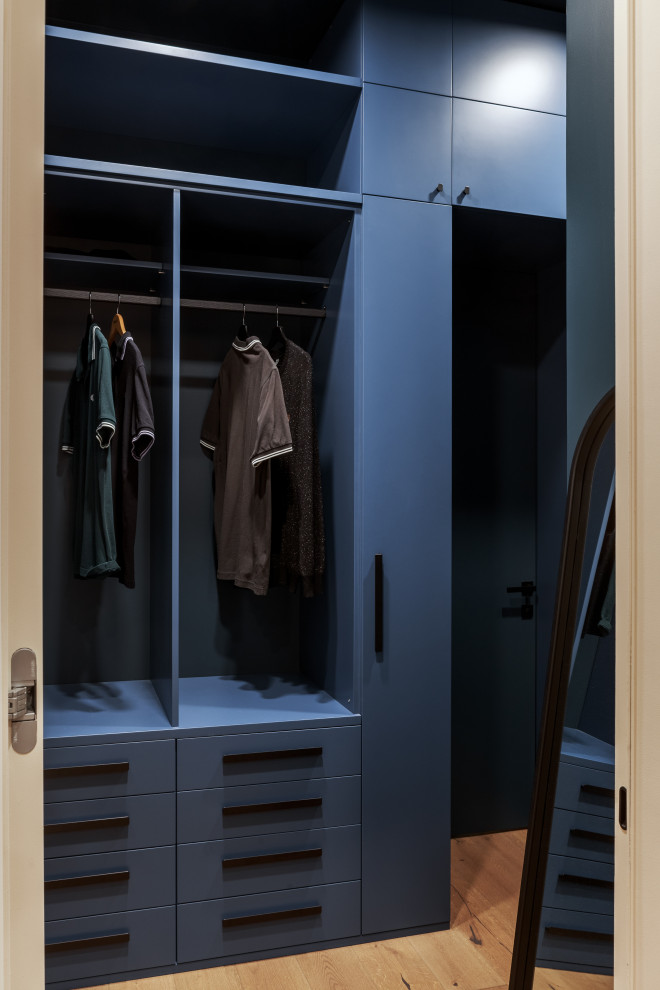 Réalisation d'une armoire encastrée design avec un placard à porte plane et des portes de placard bleues.