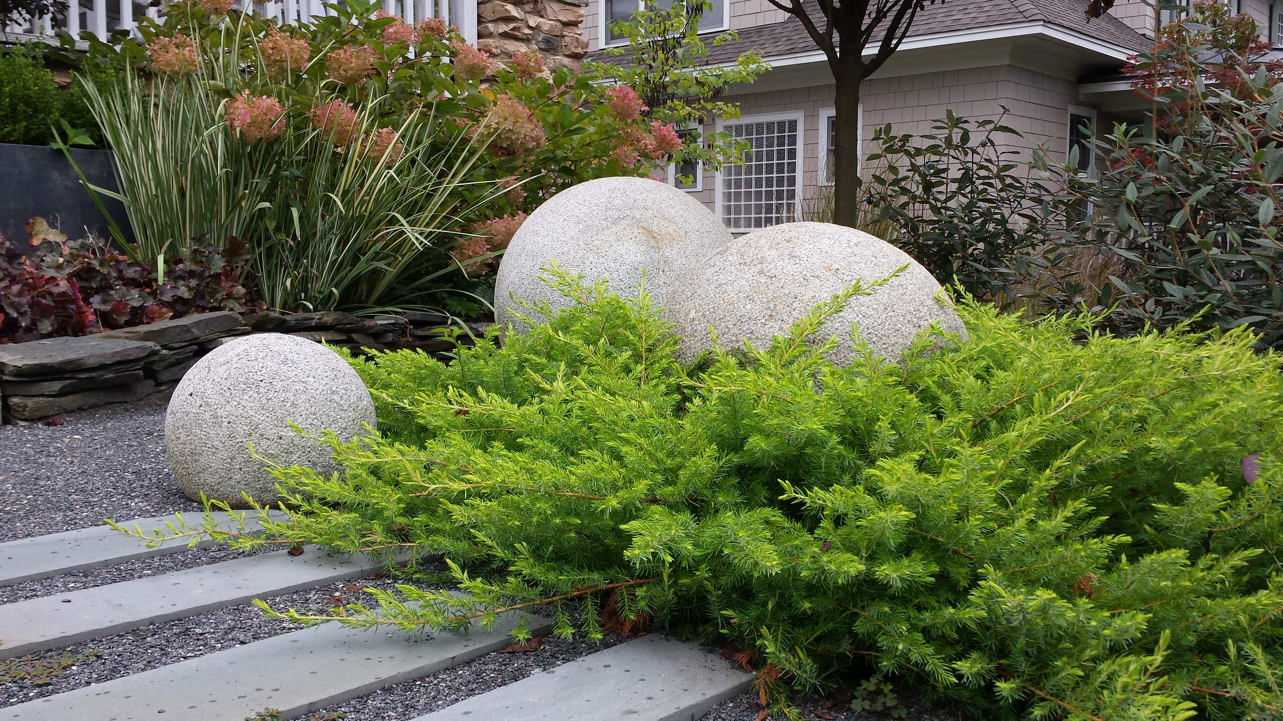 'All Gold' shore junipers with granite spheres.