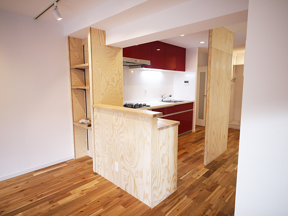 Photo of a country single-wall separate kitchen in Tokyo with red cabinets, white splashback, medium hardwood floors and with island.