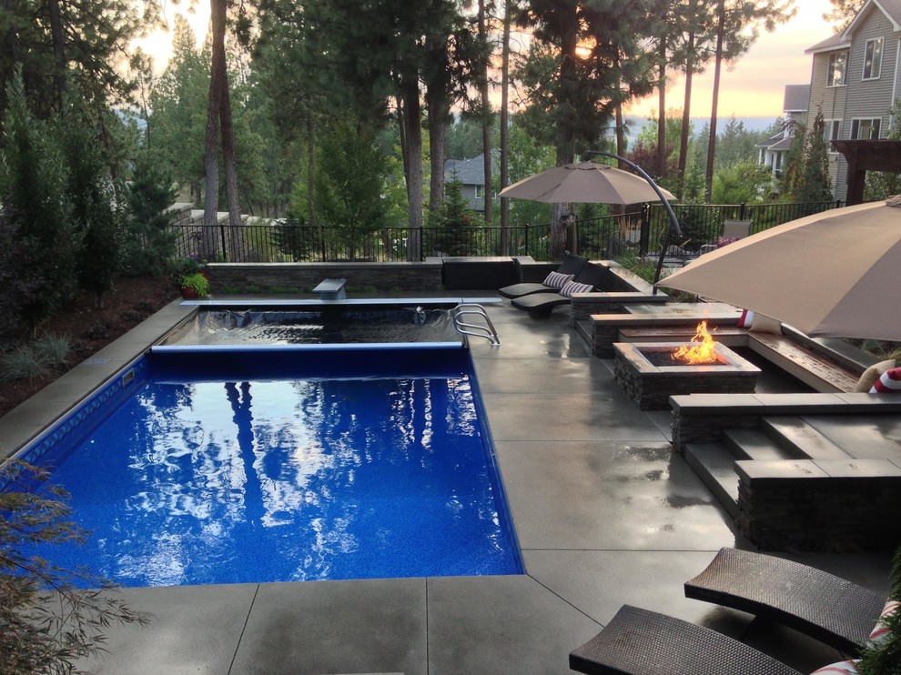 Design ideas for a small modern backyard rectangular pool in Seattle with a water feature and concrete slab.