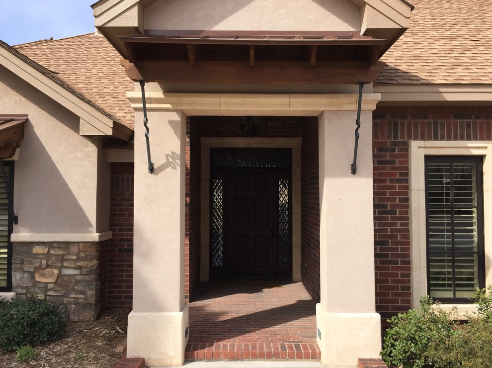 Mid-sized mountain style brick floor home design photo in Austin with beige walls and a dark wood front door