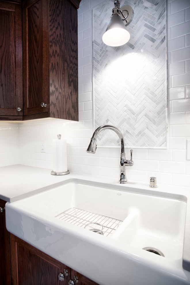 Inspiration for a mid-sized transitional u-shaped vinyl floor and gray floor eat-in kitchen remodel in Minneapolis with a farmhouse sink, shaker cabinets, dark wood cabinets, quartzite countertops, white backsplash, subway tile backsplash, a peninsula and white countertops