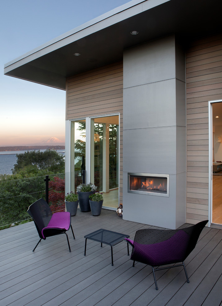 Design ideas for a large contemporary deck in Seattle with a roof extension and a fire feature.